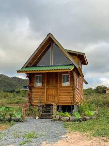 a small wooden house with a gambrel roof at Chalé Vida Boa: Paz e Aconchego in Vale do Capao