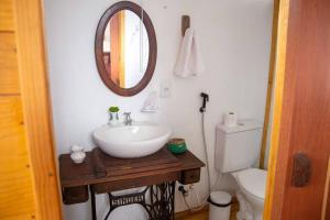 uma casa de banho com um lavatório, um espelho e um WC. em Chalé Vida Boa: Paz e Aconchego em Vale do Capao