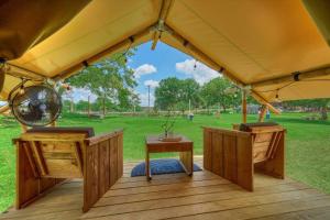 a gazebo with a table and a fan at Thistle Bee Fun - Safari Tent - BeeWeaver Honey Farm in Navasota