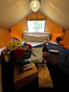 a bedroom with a bed with flowers on a table at Thistle Bee Fun - Safari Tent - BeeWeaver Honey Farm in Navasota