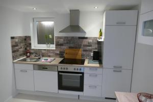 a white kitchen with a sink and a stove at Harzapart Appartement 1 Pferdchen in Walkenried
