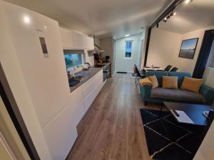 uma sala de estar com um sofá e uma cozinha em Northern living 2 room with shared bathroom em Tromsø