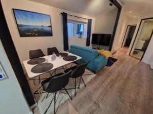 een woonkamer met een tafel en stoelen en een bank bij Northern living 2 room with shared bathroom in Tromsø