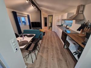 Northern living 2 room with shared bathroom في ترومسو: مطبخ وغرفة معيشة مع طاولة وكراسي