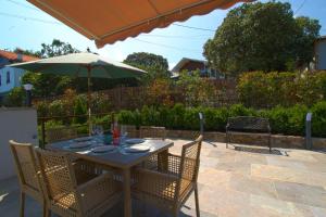 einen Tisch und Stühle mit Sonnenschirm auf einer Terrasse in der Unterkunft Marina House in Pechón