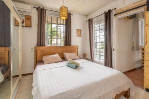 een slaapkamer met een bed met een boek erop bij Twakila Sunset Suites in La Gaulette