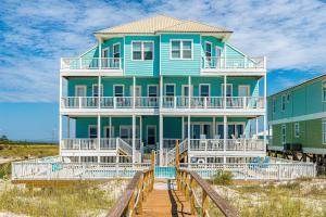 een blauw huis op een promenade voor een strand bij 2 Carats East in Gulf Shores