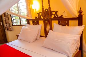 a bedroom with a bed with white sheets and pillows at 3 Bed Villa Sleeps 6 - Pool Garden Chef Option in Diani Beach +35 photos
