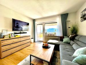 a living room with a couch and a table at Moderne, 1-Zimmer Ferienwohnung mit Bergblick in Oy-Mittelberg