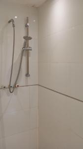 un bagno con doccia e piastrelle bianche di C.B.O. Tel Aviv 117 Allenby St. a Tel Aviv