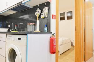 a kitchen with a washing machine in a room at Casa Familia Pestana 1, a Home in Madeira in Seixal