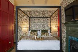 a bedroom with a canopy bed with two candles at 81 Promenade Studios in Cheltenham