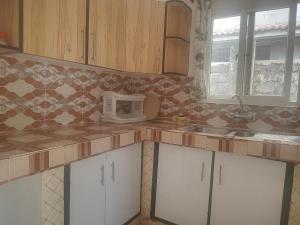 een keuken met witte kasten en een tegelmuur bij Vipingo royal homes in Kilifi