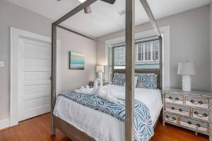 a bedroom with a canopy bed and a window at Festive Nest - Tranquil Escape Close to the Beach in Galveston