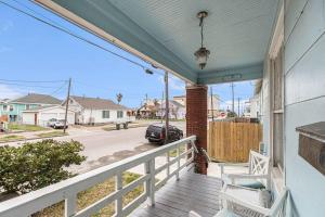 a porch with a car parked on a street at Festive Nest - Tranquil Escape Close to the Beach in Galveston