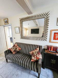 a living room with a couch and a mirror at Granary Villa in Kidderminster