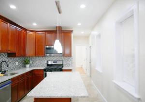 cocina con armarios de madera y encimera blanca en Newly Renovated Guest Rooms near Transportation, en Filadelfia