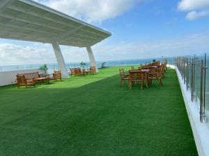 uma fila de mesas e cadeiras num relvado com o oceano em Ocean Club - Ocean Suites II em Playas