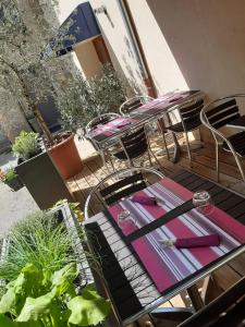 un gruppo di tavoli e sedie su un patio di Hôtel Restaurant LE SAINT AUGUSTIN a Saint-Amour