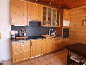 ラルプ・デュエズにあるAppartement Huez, 1 pièce, 4 personnes - FR-1-405-44のキッチン(木製キャビネット、黒いカウンタートップ付)