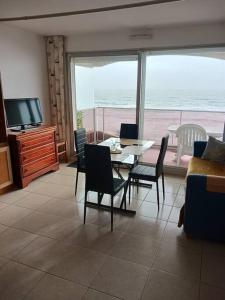 a living room with a table and chairs and a television at saint jean de mont, Superbe studio balcon face mer in Saint-Jean-de-Monts