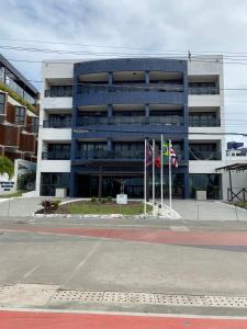 a blue building with flags in front of it at Marinas Flat 116 in Tambaú