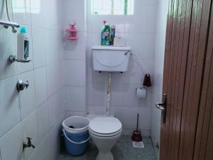 a white bathroom with a toilet and a window at Arunga's Homely Kakamega Stay in Kakamega