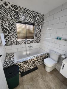a bathroom with a bath tub and a toilet at 1901 on Hightide in Amanzimtoti