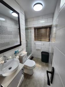 ein Badezimmer mit einem weißen WC und einem Waschbecken in der Unterkunft 1901 on Hightide in Amanzimtoti