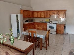 una cocina con armarios de madera y una mesa con sillas. en Casa Villa Apartments en Calliaqua