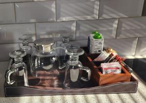 a tray with glass jars and other items in a sink at 1901 on Hightide in Amanzimtoti