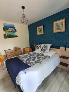 a bedroom with a large bed with a blue wall at Ty Frimousse in Sibiril +7 photos