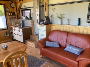 ein Wohnzimmer mit einem Sofa und einer Küche in der Unterkunft Tiny House Anneliese Hunde okay in Oberbettingen