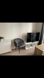 a living room with a chair and a tv at Cosy central London flat Trafalgar Square in London