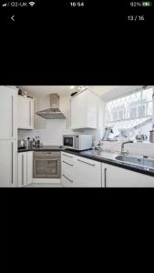 a kitchen with white appliances and a window at Cosy central London flat Trafalgar Square in London