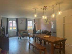 a living room with a wooden table and a dining room at L'escalier du Château T4 Duplex 9 couchages 4* in Annecy