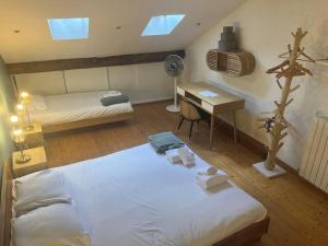 a bedroom with two beds and a desk with a fan at L'escalier du Château T4 Duplex 9 couchages 4* in Annecy