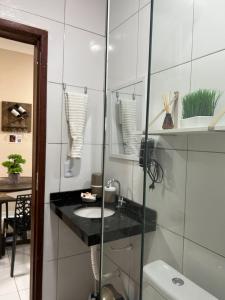 a bathroom with a sink and a glass shower at Dunas Residence - Casa 06 in Santo Amaro