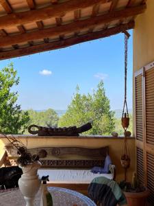 einen Balkon mit einem Tisch und einem großen Fenster in der Unterkunft Vi l'Art Wine Lodge in Piera