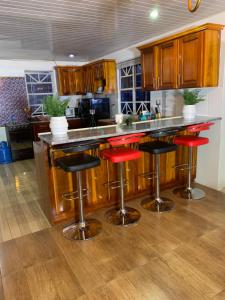 una cocina con taburetes rojos en una barra de cocina en Cozy first floor accommodation 4 guests 1 bedroom en Georgetown