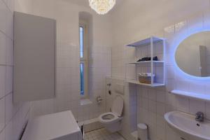 ein Badezimmer mit einem WC, einem Waschbecken und einem Spiegel in der Unterkunft Wohnung 2 neben Warschauer Platz und Spree in Berlin