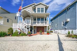 a house with an american flag in front of it at New Jersey Home - Deck, Grill and Walkable to Beach! in Ship Bottom