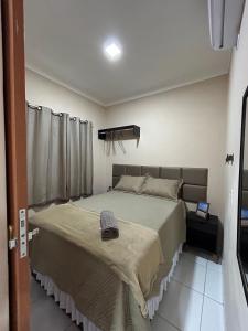 a bedroom with a bed with a hat on it at Dunas Residence - Casa 06 in Santo Amaro