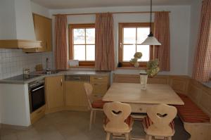 eine Küche mit einem Holztisch und Stühlen in der Unterkunft Salvenalm in Hopfgarten im Brixental