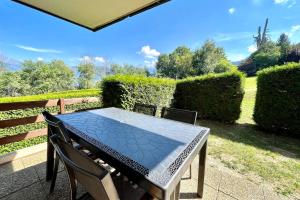 un tavolo e sedie su un patio con cespugli di Cosy 30m in the heart of Combloux a Combloux