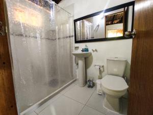 y baño con ducha, aseo y lavamanos. en Makuruma Chalet en Palomino