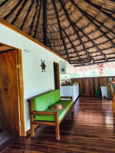 a living room with a green couch and a kitchen at Makuruma Chalet in Palomino