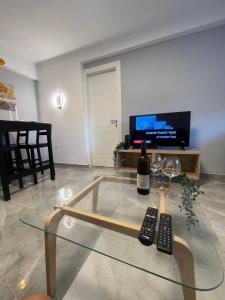 una sala de estar con una mesa de cristal con dos mandos a distancia en הטרקלין של לינוי - 5 דקות נסיעה מהים, en Ashkelon