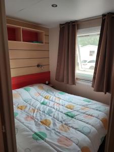 una camera da letto con un letto fiorito di Mobil-home grau du roi vagues Océanes a Le Grau-du-Roi