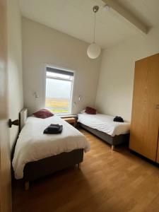 a bedroom with two beds and a window at Skálholt Cottages in Selfoss